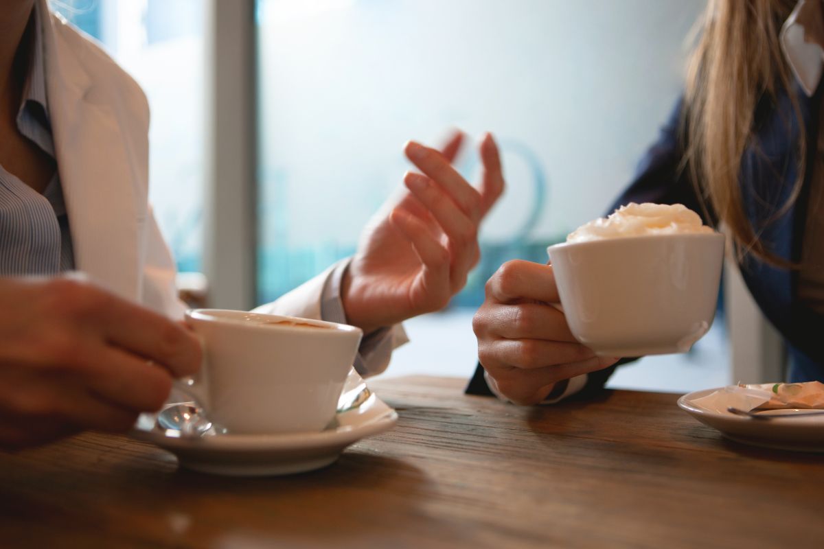 Two people in conversation over coffee.
